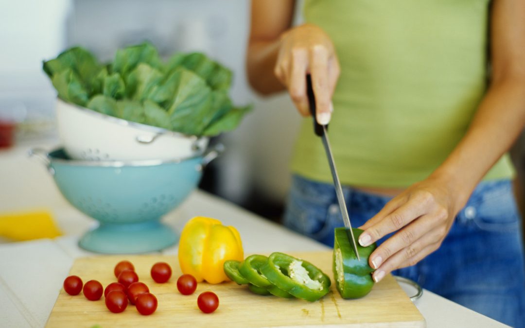 mid section view of a woman cutting vegetables